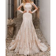 a woman in a wedding dress is standing on the cobblestone path with her hands on her hips