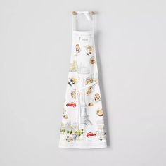 a white apron hanging on the wall with an image of paris and other famous landmarks