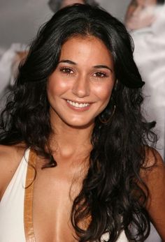 a woman with long black hair smiling at the camera