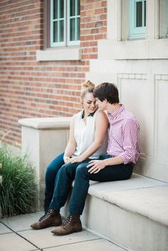 a young man and woman sitting on the steps next to each other looking at each other