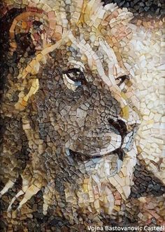 a lion made out of small pieces of broken glass and stone, with one eye open