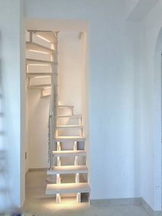 an empty room with white walls and stairs