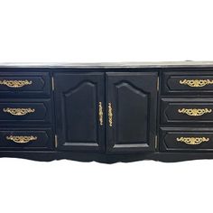 a black and gold dresser with drawers on one side and two doors on the other