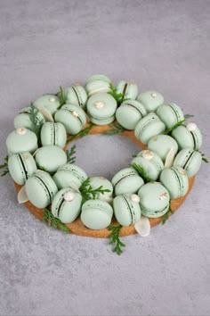 une couronne de Noël composée de 28 mini macarons, avec des petites branches de sapin et du chocolat blanc en décoration Mini Macarons, Christmas Party Snacks, Christmas Pastries, Mini Macaron, Christmas Cake Designs