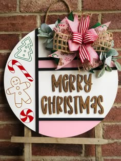 a merry christmas sign hanging on the side of a brick wall