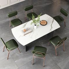 a white table with green chairs around it