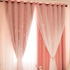 a living room with pink curtains and white furniture