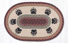 an oval rug with paw prints on the front and back of it in black, red, green, white and grey colors