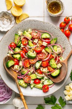 a salad with cucumbers, tomatoes and onions in a bowl on a table