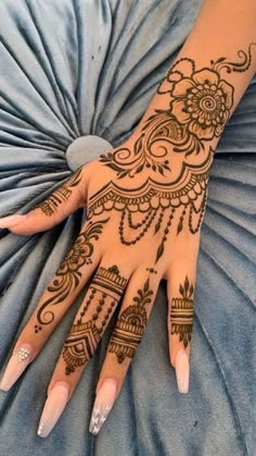 a woman's hand with henna tattoos on it