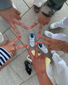 several people standing in a circle holding their hands together with different colored nail polishes on them