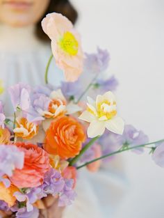 a woman holding a bouquet of flowers in her hands