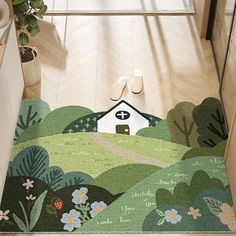 a door mat with a house and flowers on it