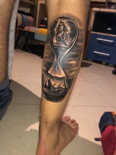 a man with a tattoo on his leg has an hourglass in the shape of a clock