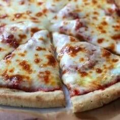 a sliced pizza sitting on top of a wooden cutting board