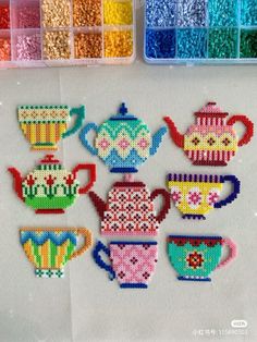 the beaded teapots and cups are next to each other in different colors