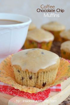 cupcakes with white frosting on a plate next to a bowl of coffee