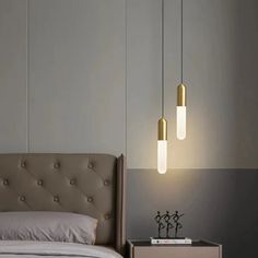 a bed with two lights hanging from it's headboard next to a night stand