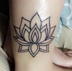 a woman's leg with a lotus tattoo on it