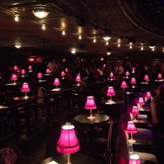 a room filled with lots of tables covered in pink lamps