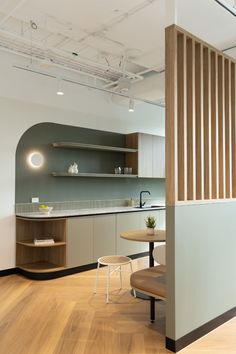 an empty kitchen and dining room with wood flooring is seen in this image from the hallway