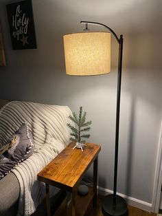 a living room with a couch, table and lamp on the side by the wall