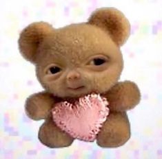 a brown teddy bear holding a pink heart