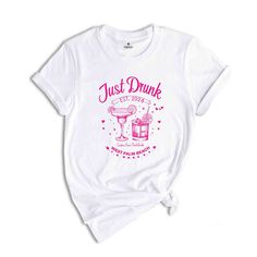 a white t - shirt with the words just drunk and a pink cocktail on it