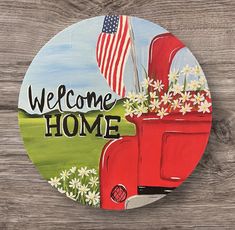 a welcome home sign with an old red truck and american flag