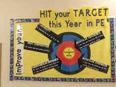 a bulletin board with words written on it and an arrow in the center that says hit your target this year in pe