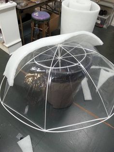 there is a potted plant under a plastic cover on the floor in an art studio