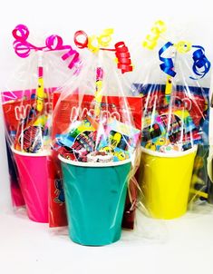 three buckets filled with candy and lollipops are sitting next to each other