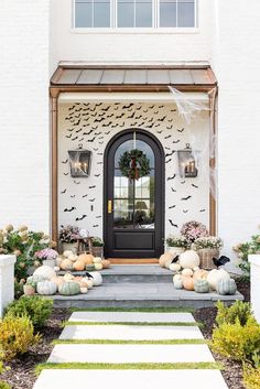 a front door decorated for halloween with pumpkins and decorations