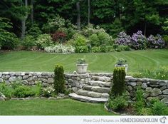 a stone wall in the middle of a garden