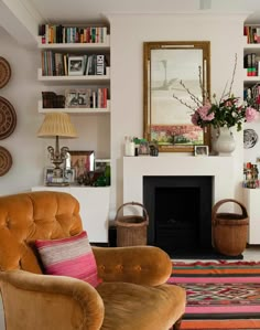 a living room filled with lots of furniture and bookshelves next to a fire place