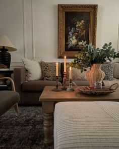 a living room with two couches and a coffee table in front of a painting