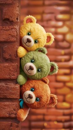 three teddy bears are hanging from a brick wall and one is holding on to the other