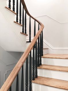 an image of a stair case with wood handrails