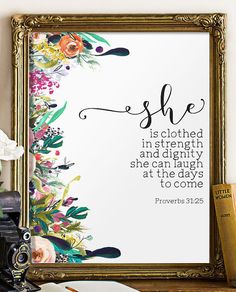 a framed print with the bible verse she is clothed in strength and mighty she can laugh at the days to come