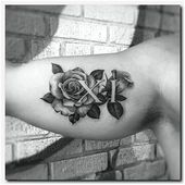 a rose tattoo with the letter k on it's left arm and two roses in the middle