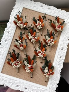 an arrangement of flowers arranged in a white frame