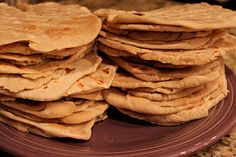 a plate full of tortillas sitting on top of a table