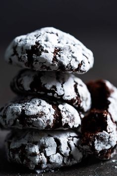 chocolate crinkle cookies stacked on top of each other with powdered sugar on them