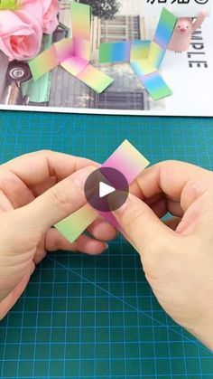 someone is making some colorful stickers out of colored paper and then using scissors to cut them