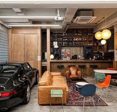 a living room filled with furniture next to a car parked in front of a bar