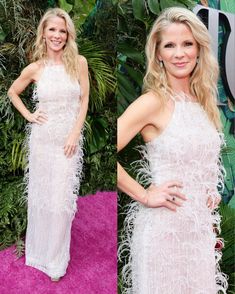 a woman in a white dress standing on a pink carpet