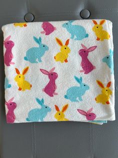 a white blanket with colorful rabbits on it