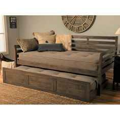 a day bed with pull out trundle and storage underneath it in a living room