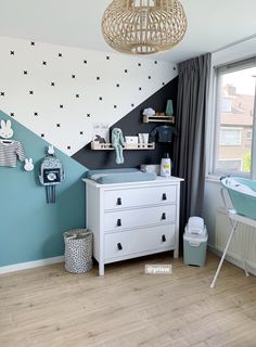 a baby's room decorated in blue and white with stars painted on the wall