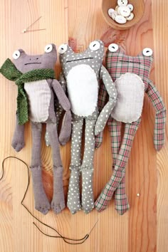 three stuffed animals laying on top of a wooden floor